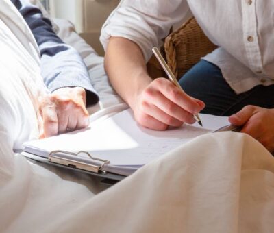 A caregiver's supportive interaction with a senior in a sunlit room, highlighting care and connection.